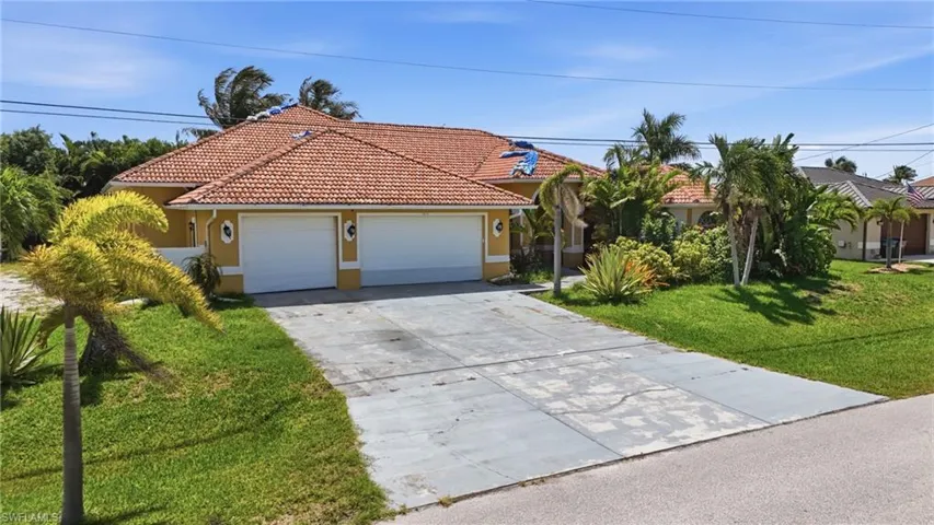 Mediterranean-style residence featuring a terracotta tile roof, stucco exterior, and a two-car garage
