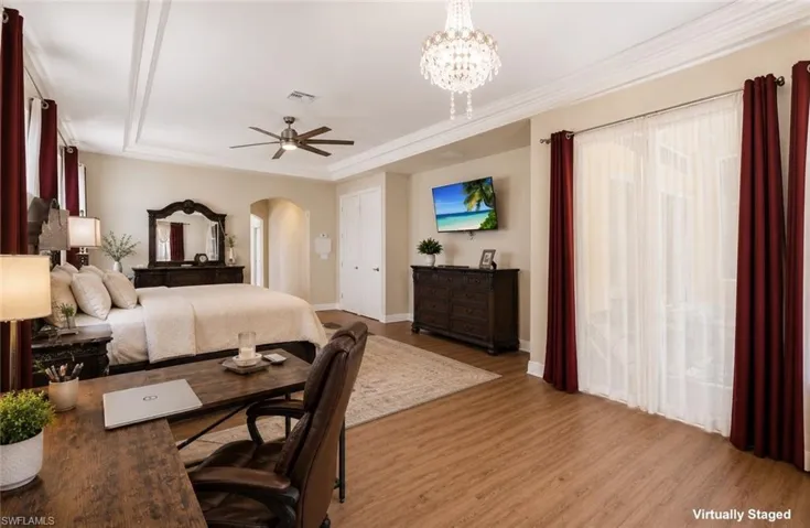 Spacious room featuring wood-finish flooring, a coffered ceiling with crown molding, and a chandelier