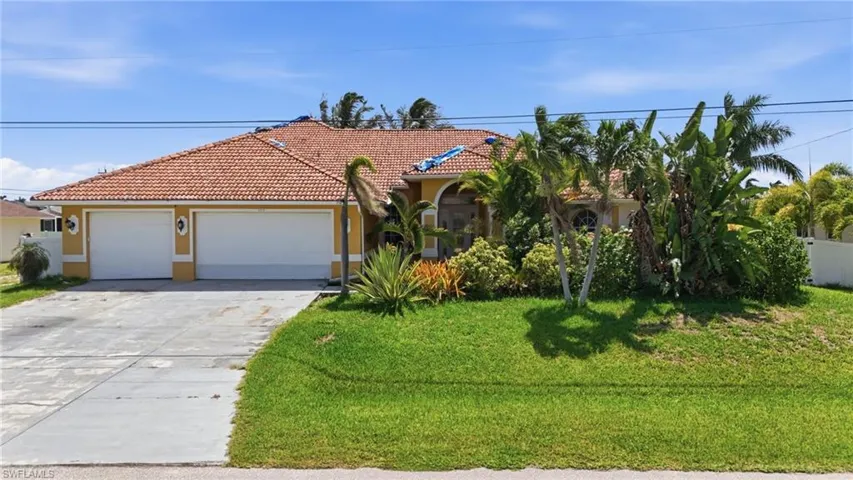 Mediterranean-inspired exterior featuring a terracotta tile roof and an attached two-car garage