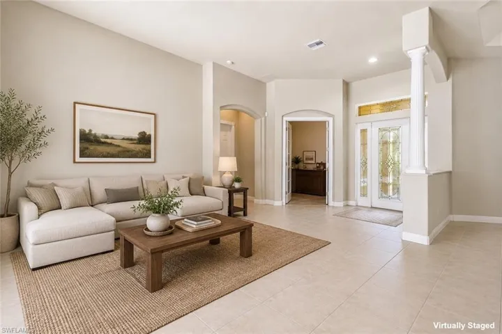 Spacious living area featuring neutral wall tones, recessed lighting, and tile flooring