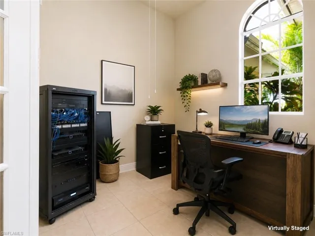 Room featuring an arched window, tile flooring, and a built-in wall shelf with integrated lighting