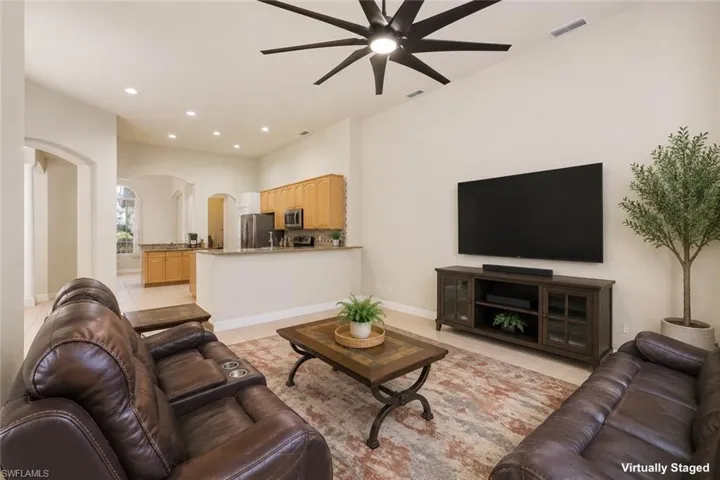 Spacious open-concept living area featuring high ceilings, recessed lighting, and a modern ceiling fan
