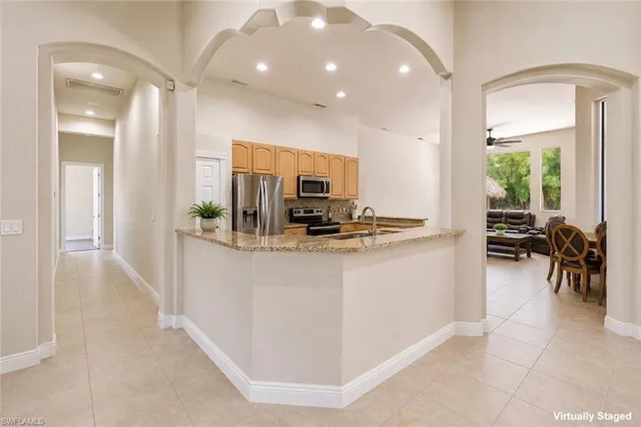 Kitchen with warm wood cabinetry, granite-finish countertops, and stainless steel appliances