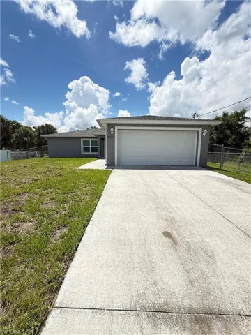 Single story home with concrete driveway, stucco siding, and an attached garage