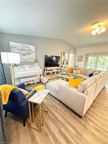 Living room with vaulted ceiling and wood finished floors