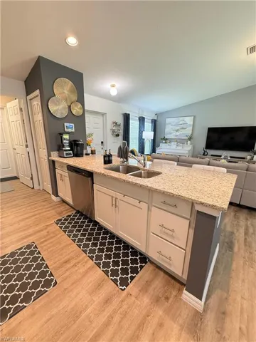 Kitchen featuring dishwasher, white cabinets, open floor plan, light wood-style floors, and recessed lighting
