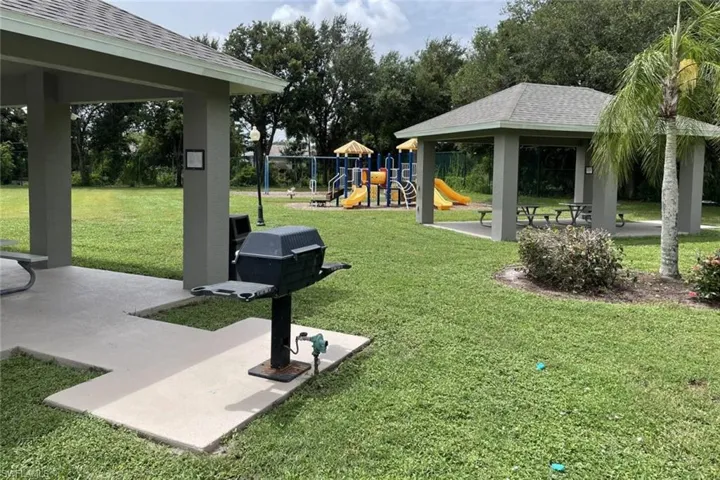 View of green lawn featuring a patio area and a playground