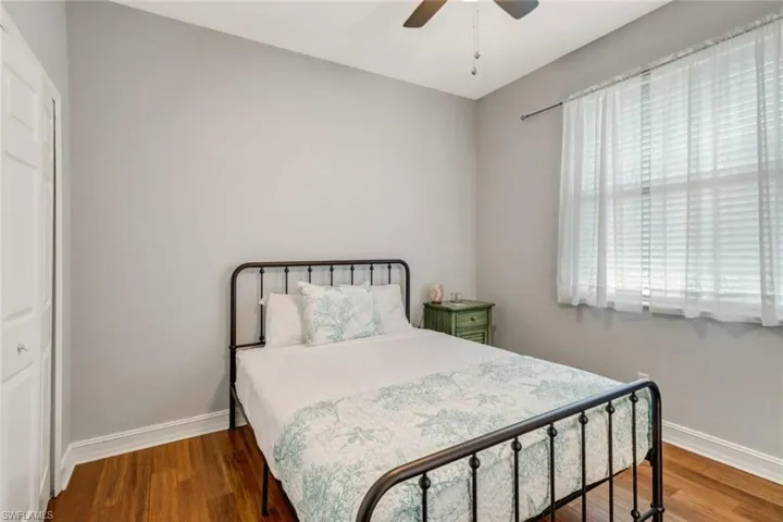 Bedroom with wood finished floors, ceiling fan, and a closet