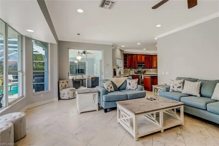 Living area featuring ceiling fan, recessed lighting, and crown molding
