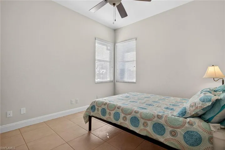 Tiled bedroom with baseboards and ceiling fan