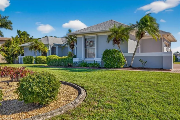 View of front of property with stucco siding and a front yard