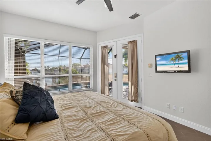 Bedroom featuring french doors, access to outside, wood finish floors, and ceiling fan