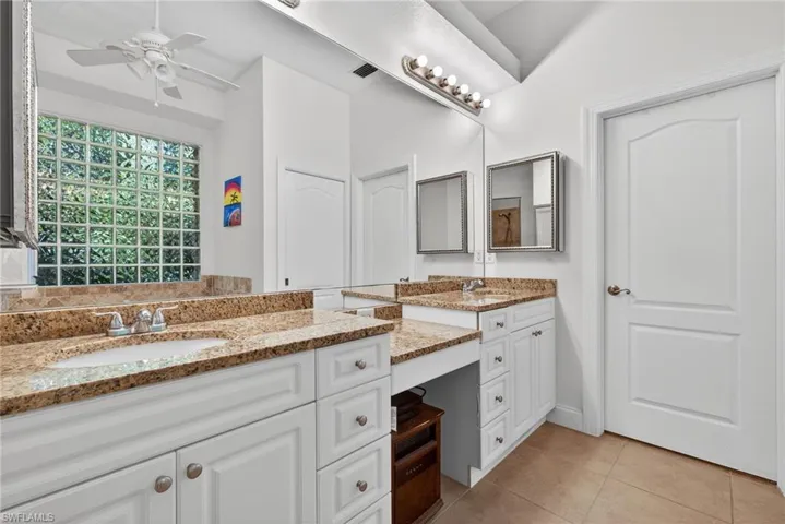 Full bath with vanity, light tile patterned flooring, and ceiling fan