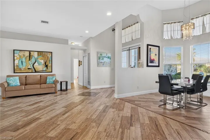 Dining room featuring a towering ceiling, light wood-style flooring, and a chandelier
