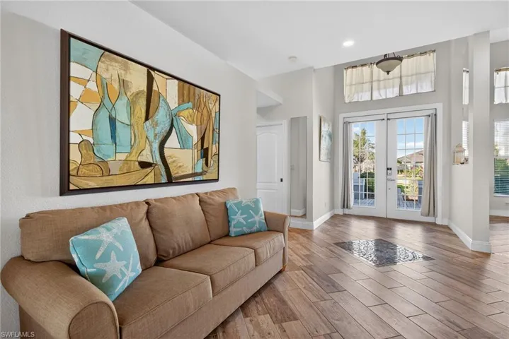 Foyer with french doors, wood finished floors, and a high ceiling