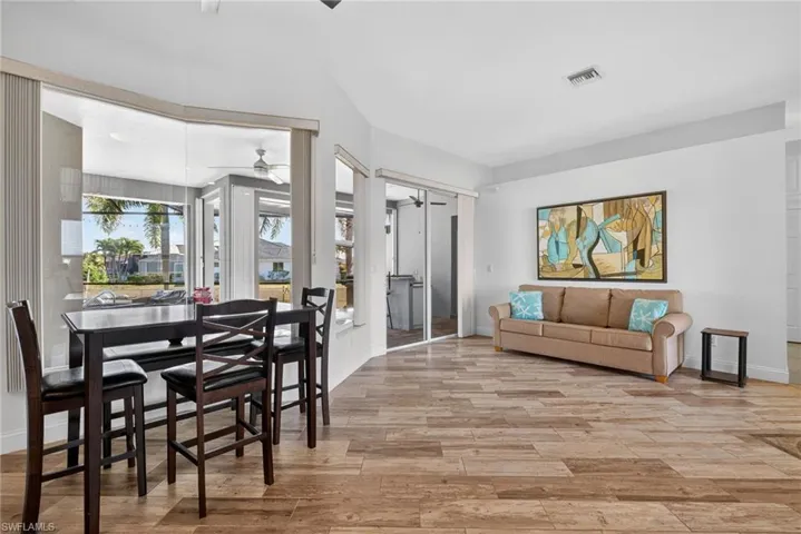 Living room with light wood-style floors and a sunroom
