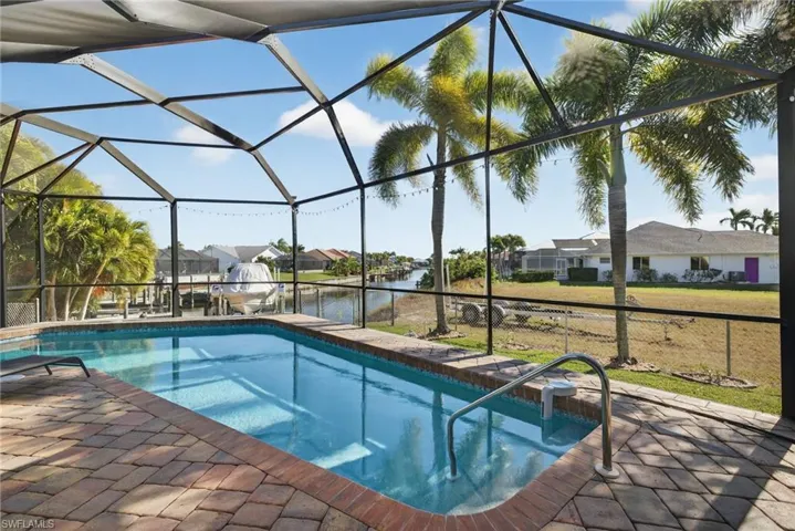Outdoor pool with glass enclosure, a residential view, a sunroom, and a water view