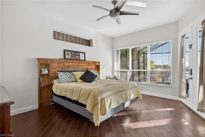 Bedroom featuring wood finish floors, a ceiling fan, and access to outside