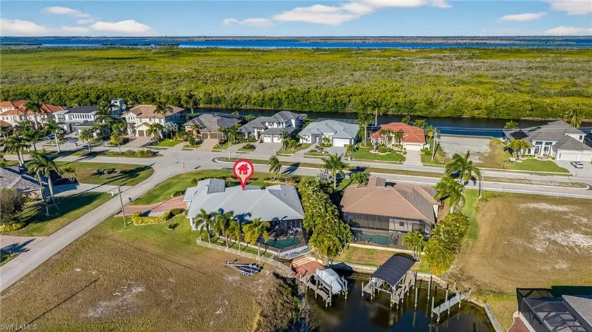 Aerial perspective of suburban area featuring a large body of water and a forest
