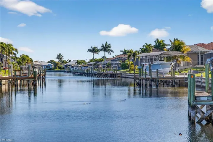 Water view featuring nearby suburban area, a dock, and boat lift
