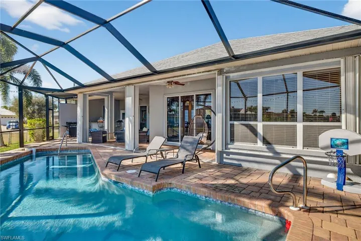 Swimming pool with a patio area, a sunroom, and glass enclosure