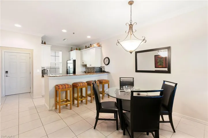 Dining space with ornamental molding, baseboards, recessed lighting, and light tile patterned flooring