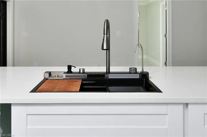 Interior details with light countertops, a sink, and white cabinets