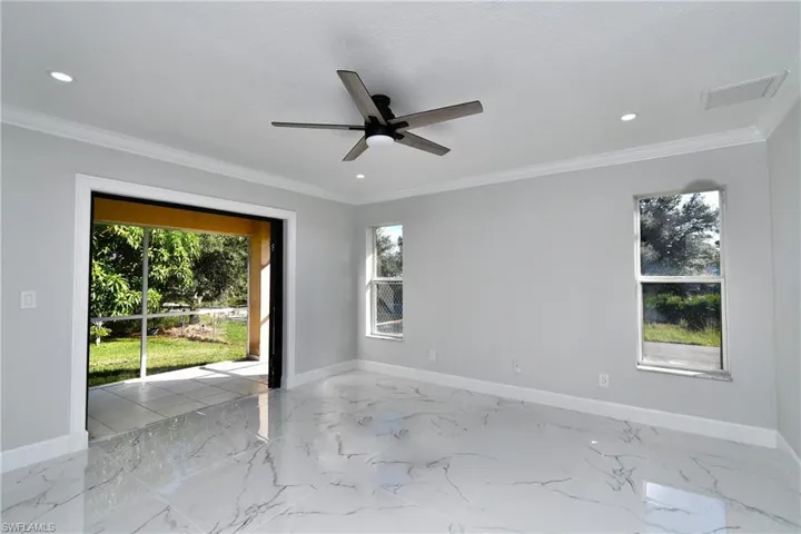Spare room with baseboards, ceiling fan, and ornamental molding
