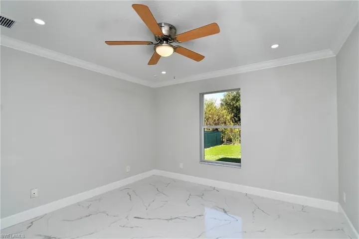Empty room featuring visible vents, crown molding, baseboards, ceiling fan, and recessed lighting