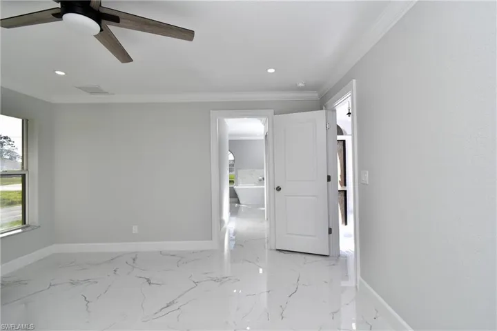 Unfurnished room featuring baseboards and crown molding