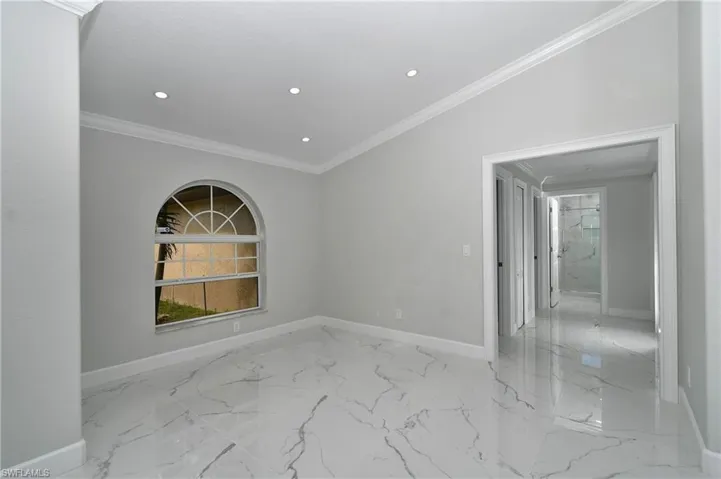 Spare room with baseboards, marble finish floor, and ornamental molding
