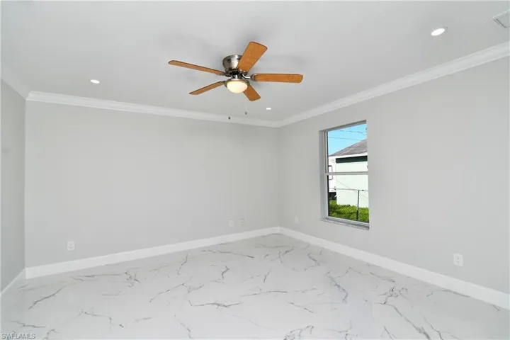 Spare room with recessed lighting, ornamental molding, baseboards, and ceiling fan