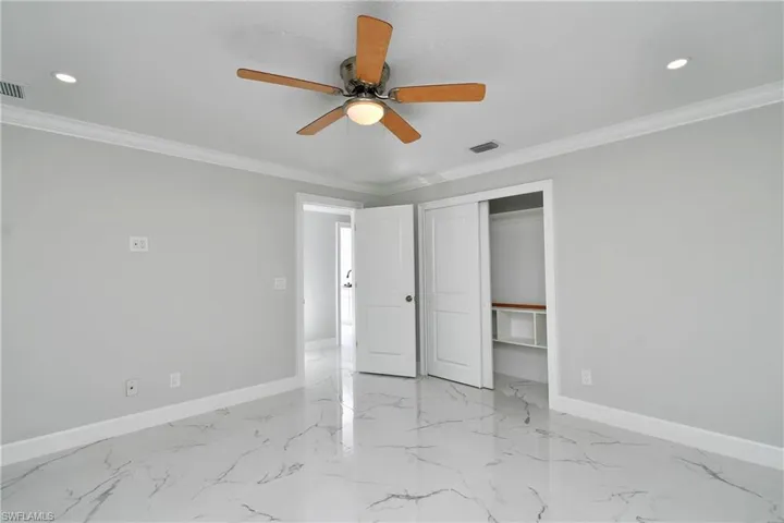 Unfurnished bedroom with baseboards, visible vents, and crown molding