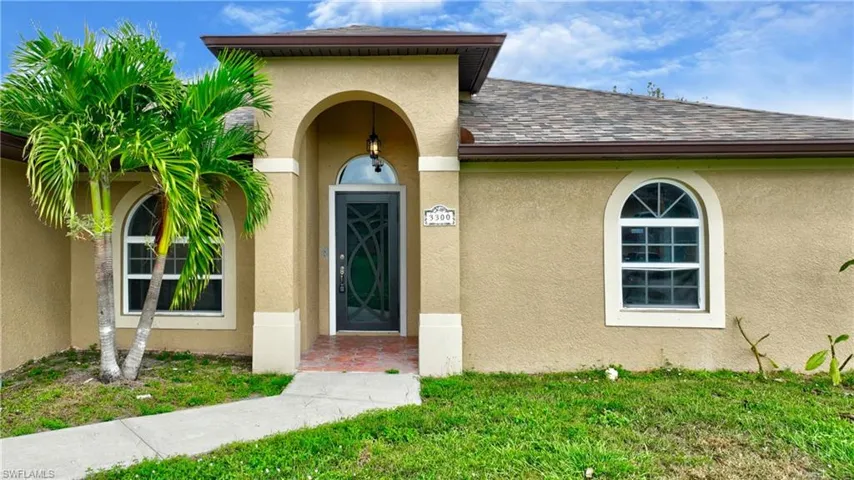 Doorway to property featuring stucco siding and a shingled roof