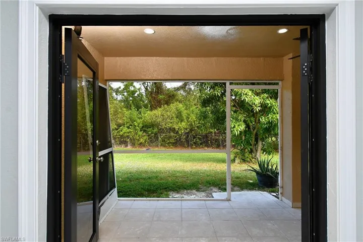 Doorway to outside with light tile patterned floors, recessed lighting, and a wealth of natural light