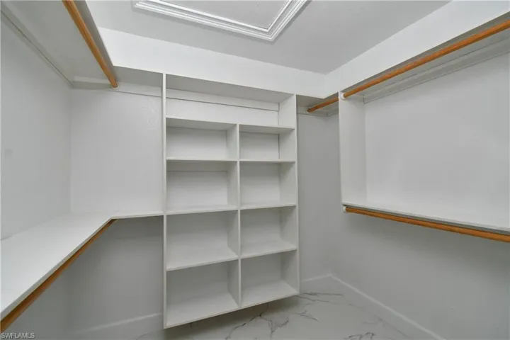 Walk in closet with marble finish floor