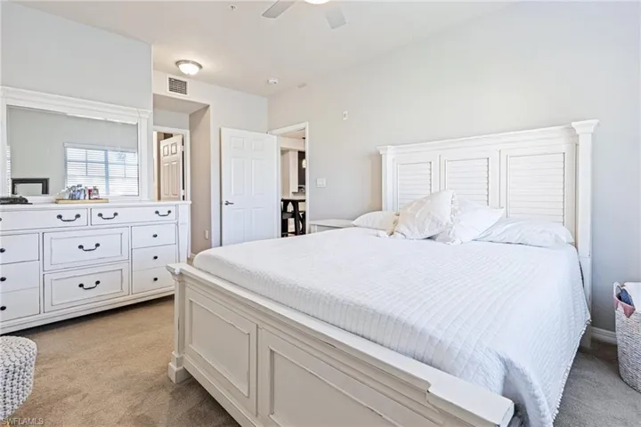 Bedroom with ceiling fan and light colored carpet