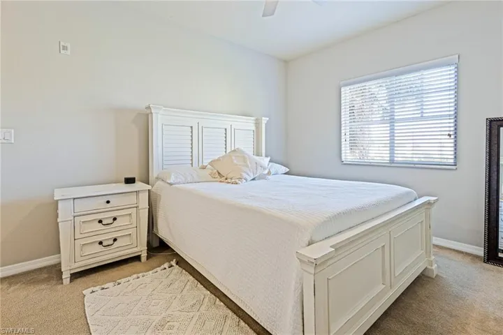Carpeted bedroom featuring ceiling fan