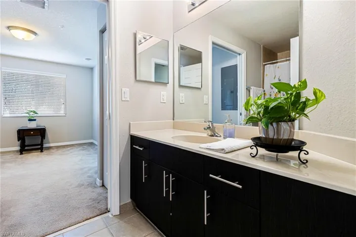 Bathroom with tile flooring, a textured ceiling, and vanity