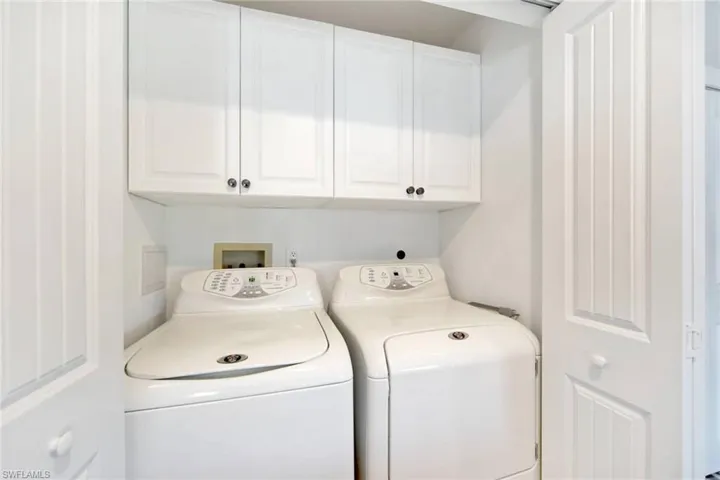 Washroom featuring cabinet space and washing machine and dryer