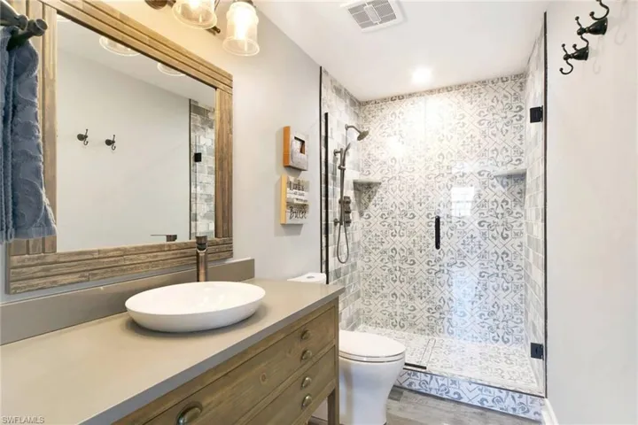 Bathroom with a shower stall, vanity, and light wood-type flooring