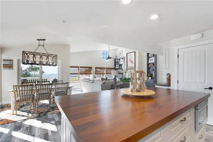 Dining area featuring dark wood-style floors, lofted ceiling, and recessed lighting