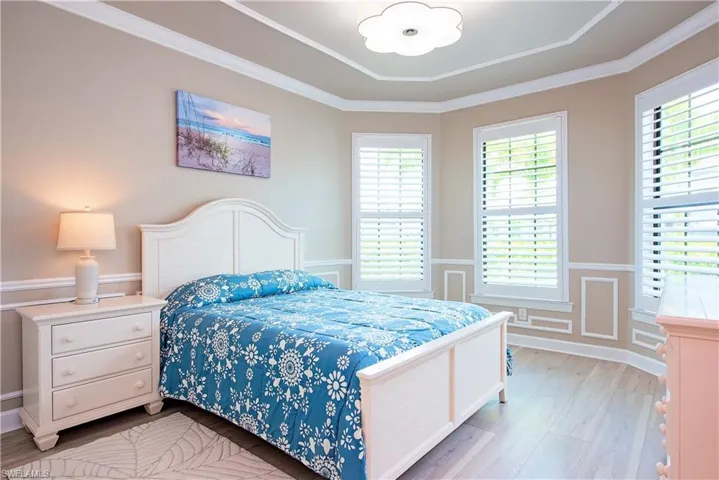 Bay window featuring three large windows with plantation shutters, crown molding, chair rail, and picture frame molding