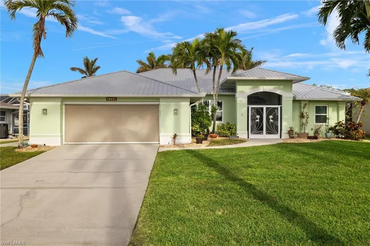Single story home featuring stucco siding, driveway, metal roof, and an attached garage