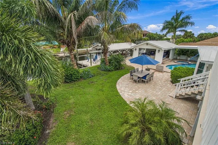 Expansive paver patio with a built-in swimming pool and spa