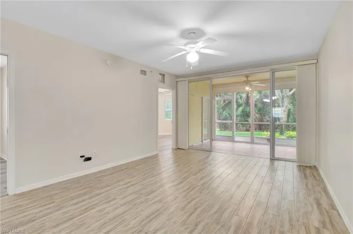 Empty room featuring ceiling fan, light wood-type flooring, and baseboards