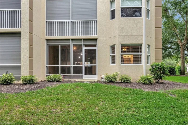 Rear view of house featuring stucco siding and a lawn