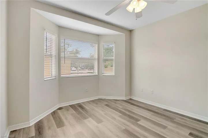Empty room with light wood-style flooring, a ceiling fan, and baseboards