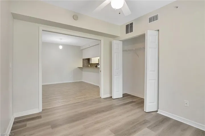 Unfurnished bedroom featuring wood finished floors, baseboards, a closet, and ceiling fan