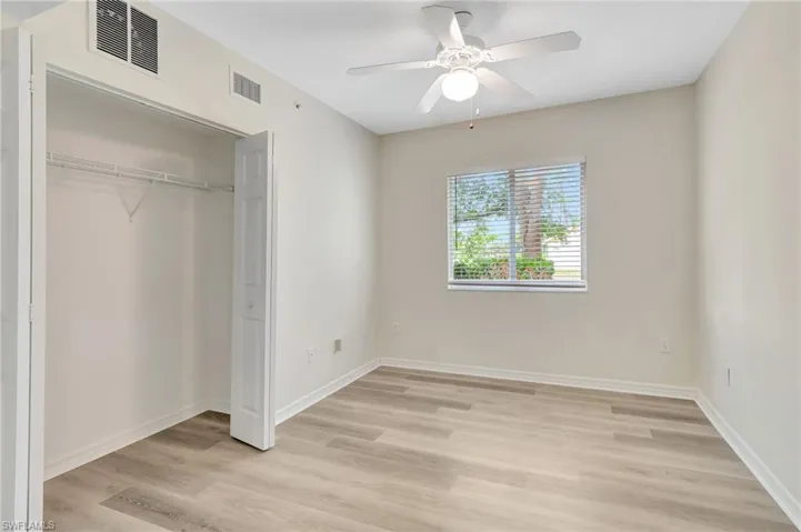 Unfurnished bedroom featuring light wood-style floors, a closet, a ceiling fan, and baseboards